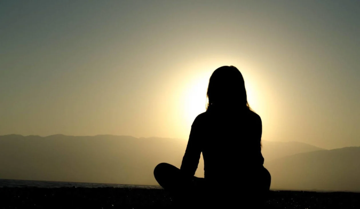 self-improvement woman meditating in sun shadow